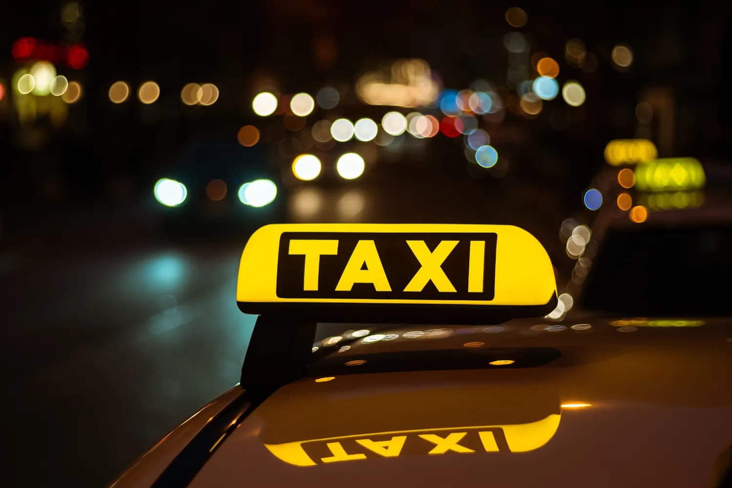 TAXI tető jelvény éjszakai városi háttérrel